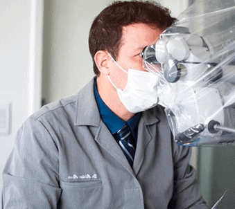 Dr Adriano Abreu usando microscópio odontológico